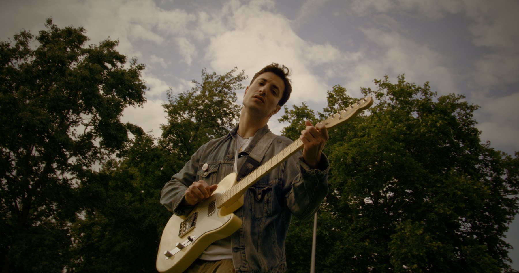Huebline playing an outdoor set with trees behind the stage